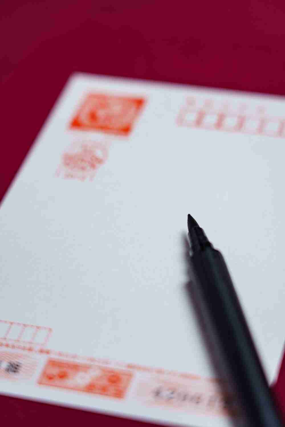 日本の年賀はがきに文字を書く手元 / A hand writing a Japanese New Year postcard